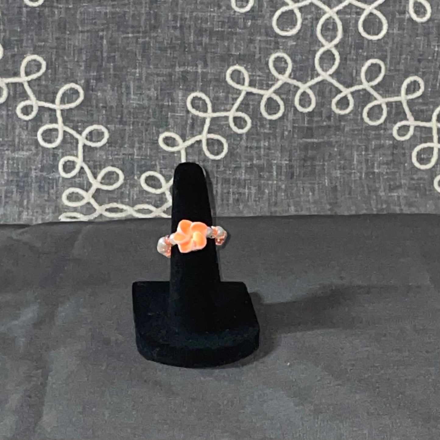 Peach Blossom Ring on a black ring display stand