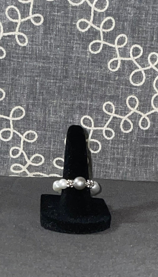 Smoky Pearl Grace Ring with silver-gray glass pearl centerpiece and sparkling crystal accent beads on a black ring display